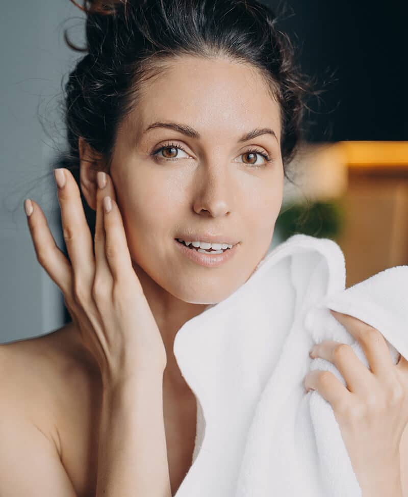 Woman wiping her face with a towel