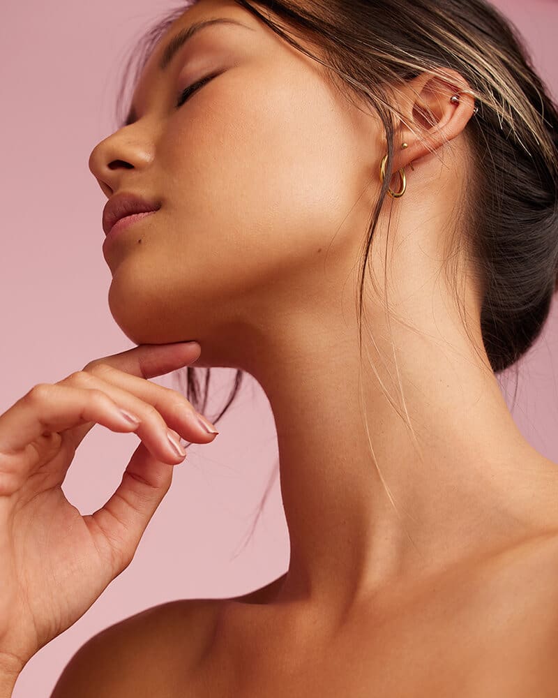 Side and under profile of a woman's face with her chin in her left hand,